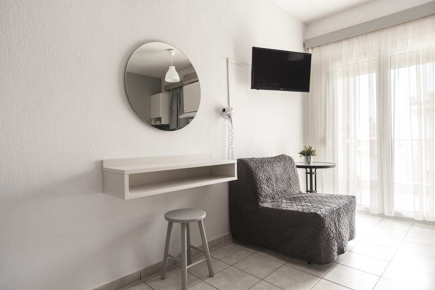 Studio corner with round mirror, desk and armchair